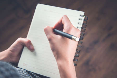 woman hand holding pen with notepadの写真素材