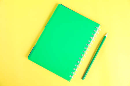notepads with pencil on the yellow backgroundの写真素材