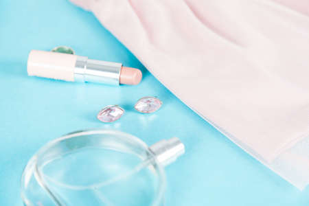 pink dress with perfume and Lipstick on deskの写真素材
