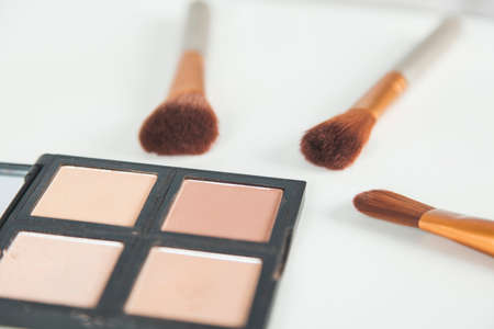 Set of decorative cosmetics and brushes on desk