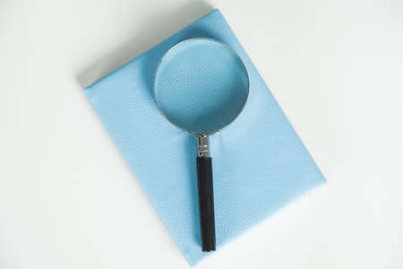 magnifier on notepad on the table background