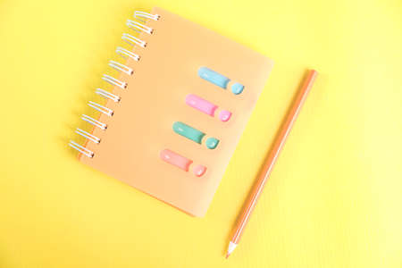 notepad with pencil on the yellow deskの写真素材