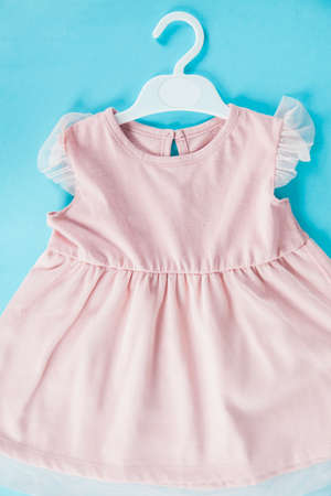 baby pink dress on the blue deskの写真素材