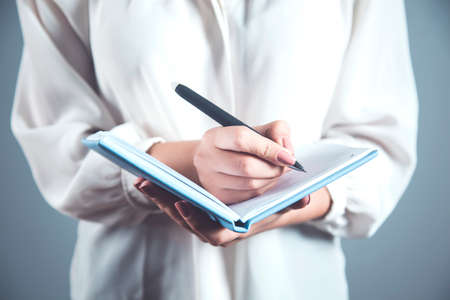 woman hand pen and notepad on the desk