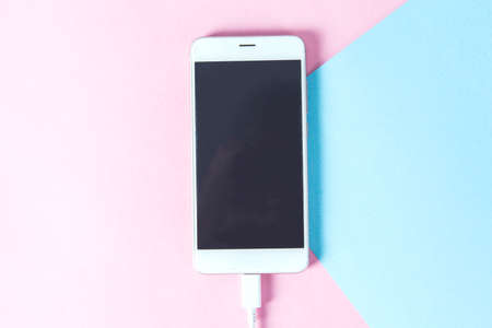 smart phone with usb cable on the blue desk