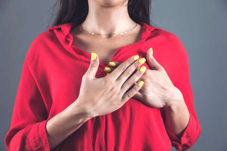 woman hands in heart on dark background