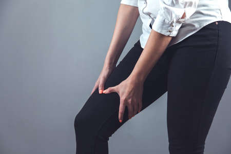 woman hand on ache feet on gray backgroundの写真素材
