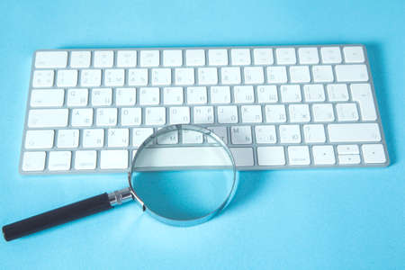 magnifier and computer on the deskの写真素材