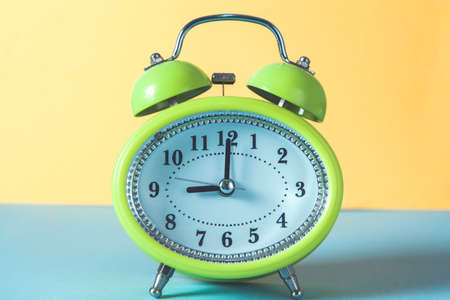 green clock on the blue desk background