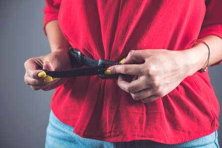 woman hand in her belt on dark backgroundの写真素材