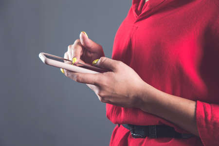 woman hand holding smart phone on gray background