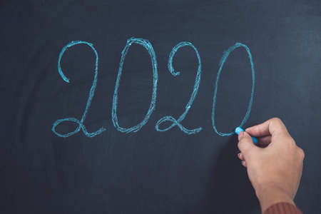 woman hand 2020 text on the chalkboard