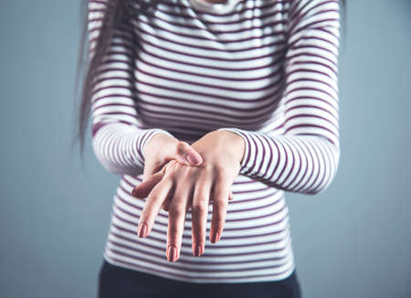 woman ache hand  on the dark backgroundの写真素材