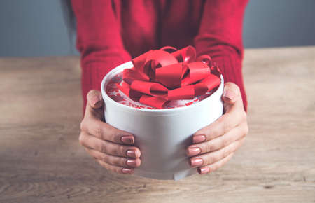 woman hand holding gift box on desk