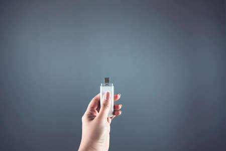 woman hand holding flash on gray background