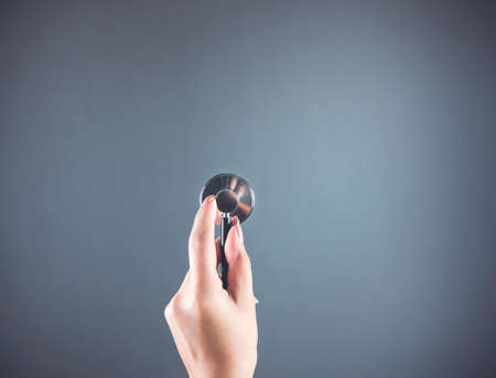 woman hand stethoscope on the dark background