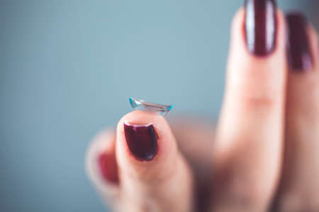 woman hand lenses on gray backgroundの写真素材