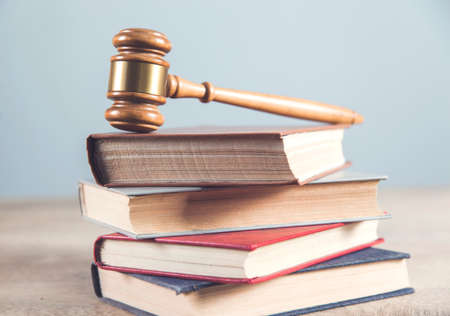 wooden judge on books on the gray wall backgroundの写真素材