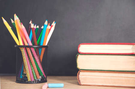 books with pencils on the chalkboard background