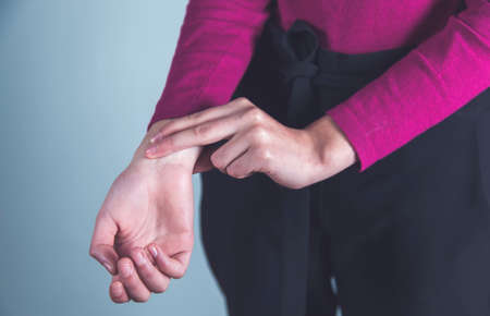 woman hand in pulse on gray background