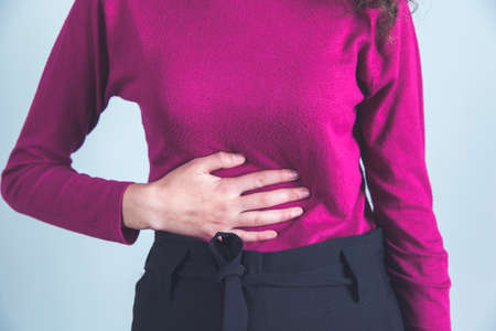 young woman hand in ache stomacheの写真素材