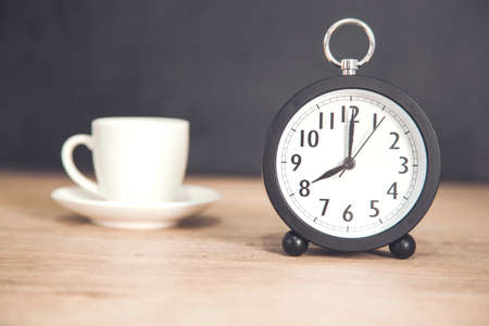 cup of coffee with clock on deskの写真素材