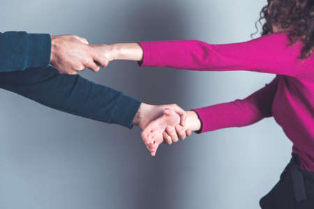 angry man with woman hands on gray backgroundの写真素材