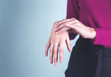 woman hand in ache hand on gray backgroundの写真素材