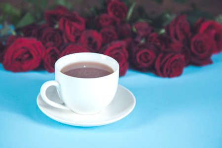 red rosses with cup of coffee on the deskの写真素材