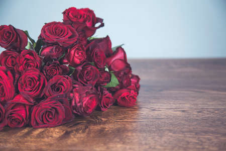 bouquet of red roses on wooden deskの写真素材