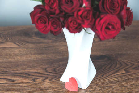 bouquet of red roses with heart on deskの写真素材