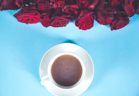 red rosses with cup of coffee on the deskの写真素材