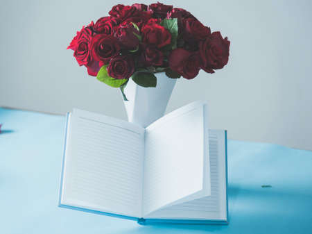 notepad with bouquet of roses on desk