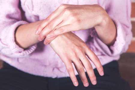 young woman hand in ache hand on dark background