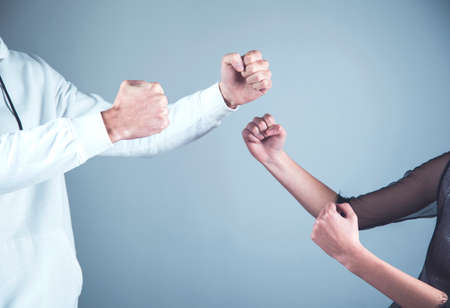 angry woman and man  fists on dark backgroundの写真素材