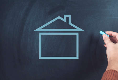 woman hand house on chalkboad backgroundの写真素材