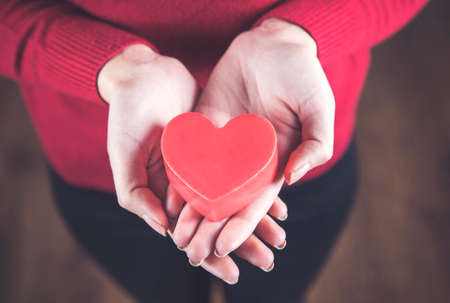 young woman hand holding red heart の写真素材
