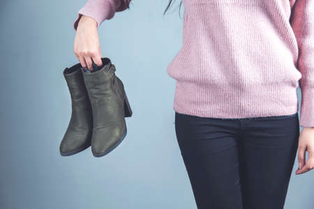 woman hand holding shoes on gray backgroundの写真素材