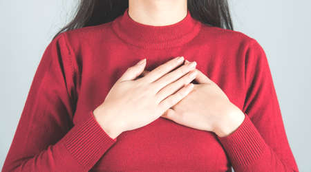 happy woman hand in heart on gray backgroundの写真素材