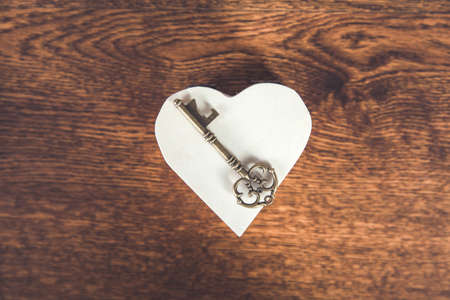 key on the wooden heart on the deskの写真素材