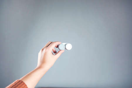 woman hand holding lenses on gray backgroundの写真素材