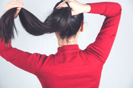 woman hand hair tail on gray backgroundの写真素材