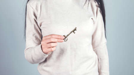 woman hand key on gray wall backgroundの写真素材