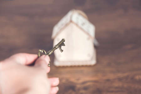 woman hand key and house model on deskの写真素材