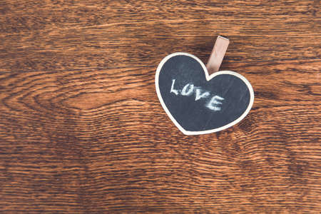 love text on heart chalkboard on wooden desk