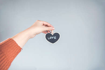woman hand holding heart on gray backgroundの写真素材