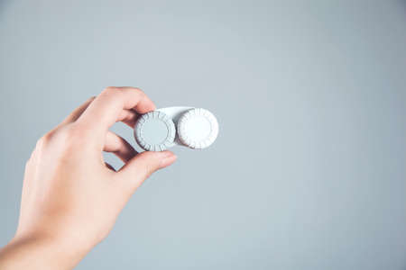 woman hand holding lensses on gray backgroundの写真素材