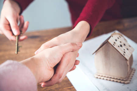 two woman hands  house model with documents on desk