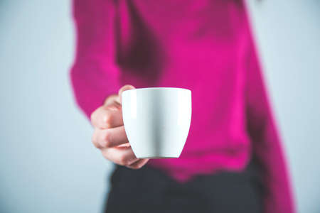 woman hand cup of coffee on grey background