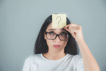 woman hand drawing question mark in headの写真素材